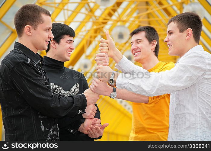 group of young men make piramid from hands