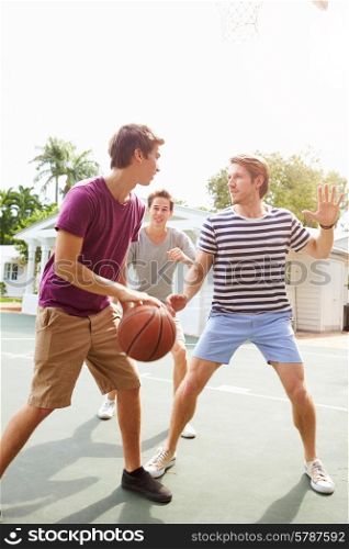 Group Of Young Men Playing Basketball Match