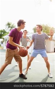 Group Of Young Men Playing Basketball Match