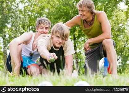 Group of young men playing boule in a park outdoors in summer