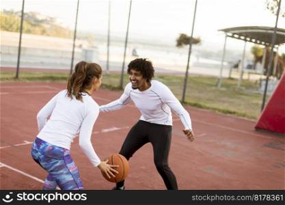 Group of young multiethnic young people  playing basketball on court
