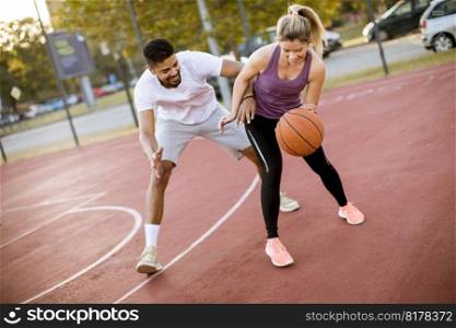 Group of young multiethnic young people  playing basketball on court