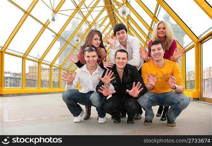 group of young people demonstrates open palms on footbridge