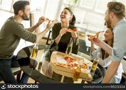 Group of young people eating pizza and drinking cider in the modern interior