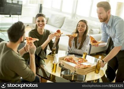 Group of young people eating pizza and drinking cider in the modern interior