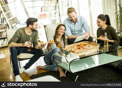 Group of young people eating pizza and drinking cider in the room