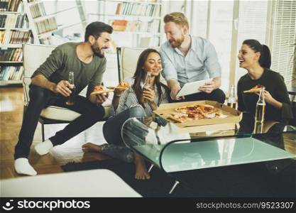 Group of young people eating pizza and drinking cider in the room
