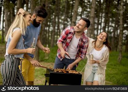 Group of young people enjoying barbecue party in the nature