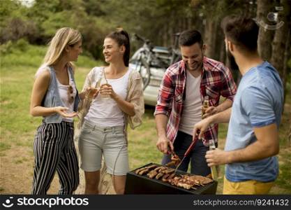 Group of young people enjoying barbecue party in the nature