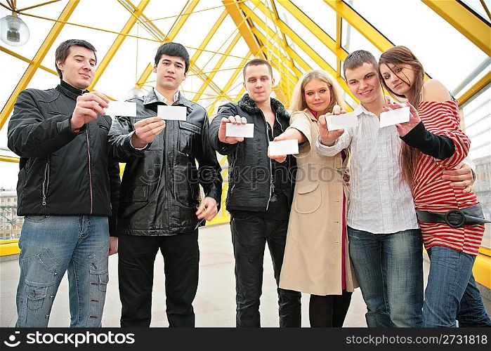 group of young people hold blank cards in hands . focus on cards