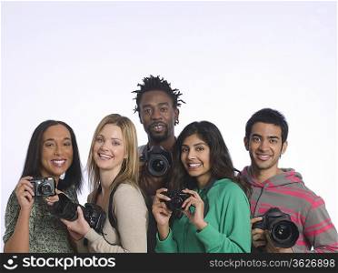 Group of young people holding cameras, studio shot