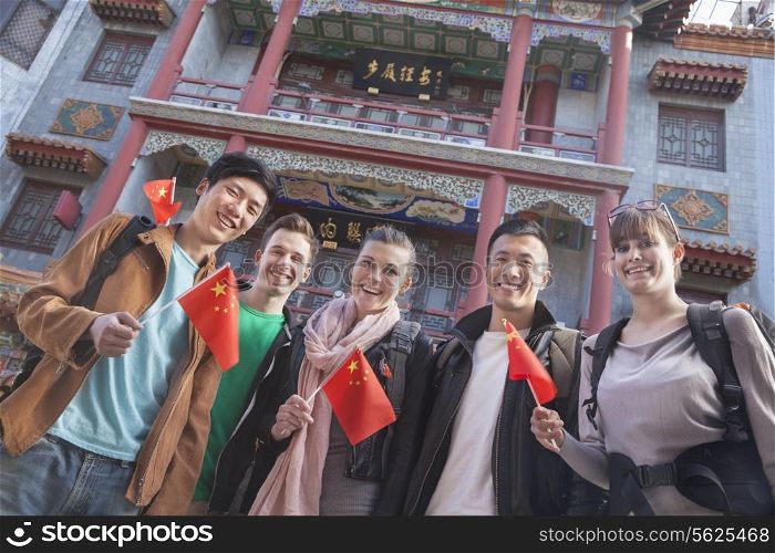 Group of young people holding Chinese flags, portrait.