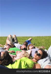 group of young people lying in field