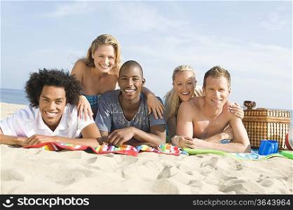 Group of young people lying on sand