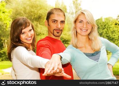 Group of young people put hands on top of each other
