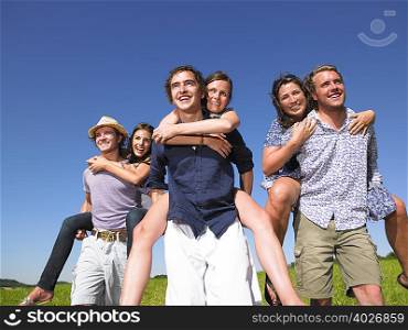 group of young people riding piggy back