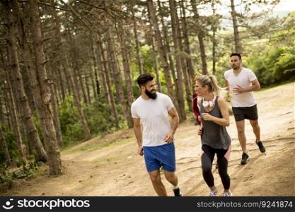 Group of young people run a marathon through the forest