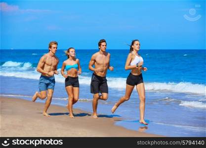 group of young people running in the beach in summer vacation