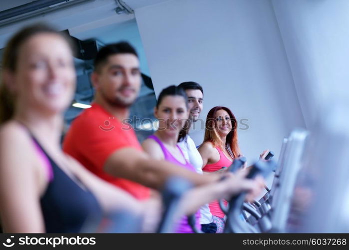 group of young people running on treadmills in modern sport gym