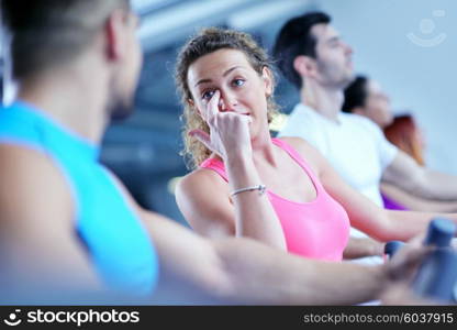 group of young people running on treadmills in modern sport gym