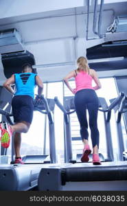 group of young people running on treadmills in modern sport gym