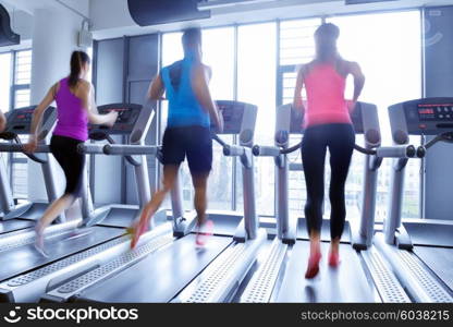 group of young people running on treadmills in modern sport gym