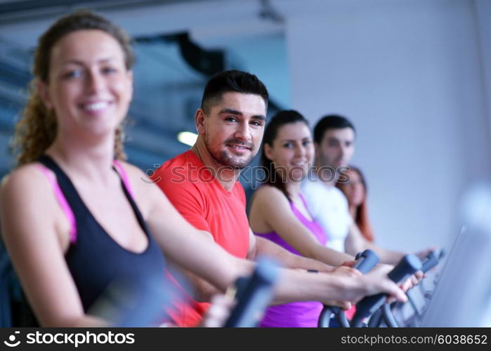 group of young people running on treadmills in modern sport gym