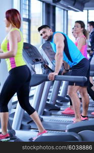 group of young people running on treadmills in modern sport gym