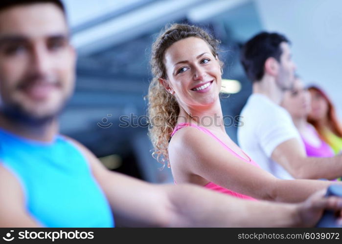 group of young people running on treadmills in modern sport gym