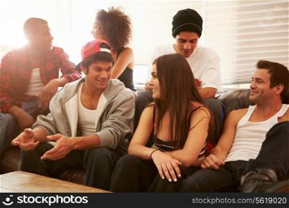 Group Of Young People Sitting On Sofa And Talking