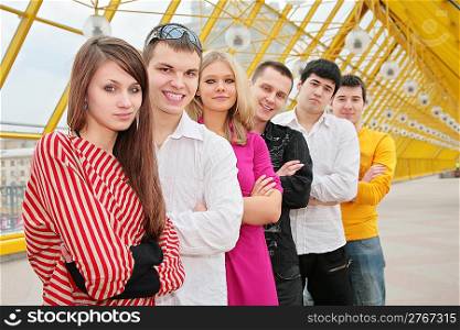 group of young people stand on footbridge