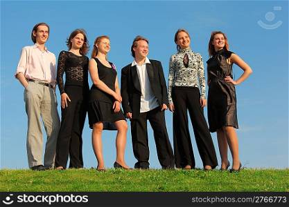 group of young people stand on meadow