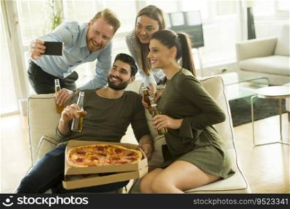 Group of young people taking selfie on the  pizza party in the room
