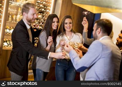 Group of young people toasting with white wine at home
