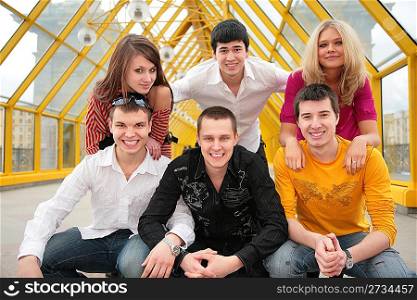 group of young persons pose on footbridge