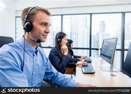 Group of young profession call center operator agent with headsets working in office. Business telemarketing service people concentrating on having conversation work and talking to customer friendly