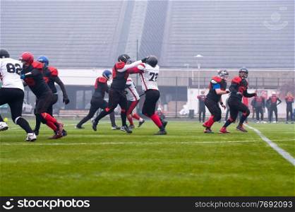 group of young professional american football players in action during training match on the stadium field
