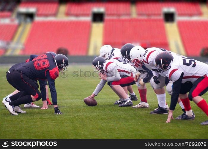 group of young professional american football players ready to start during training match on the stadium field