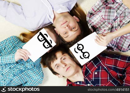 Group of young smiling people lying on floor in circle with phone symbols. Let&rsquo;s be friends