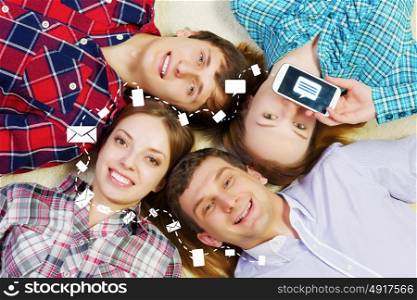 Group of young smiling people lying on floor in circle with phone symbols. Let&rsquo;s be friends