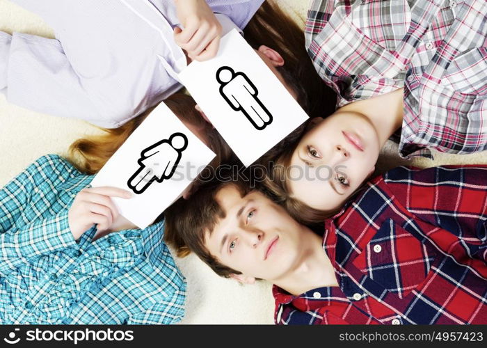 Group of young smiling people lying on floor in circle with phone symbols