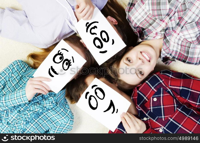 Group of young smiling people lying on floor in circle with phone symbols