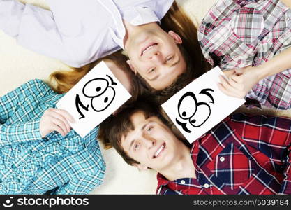 Group of young smiling people lying on floor in circle with phone symbols