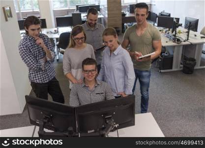 group of young startup business people standing as team at office desk while working on everyday job