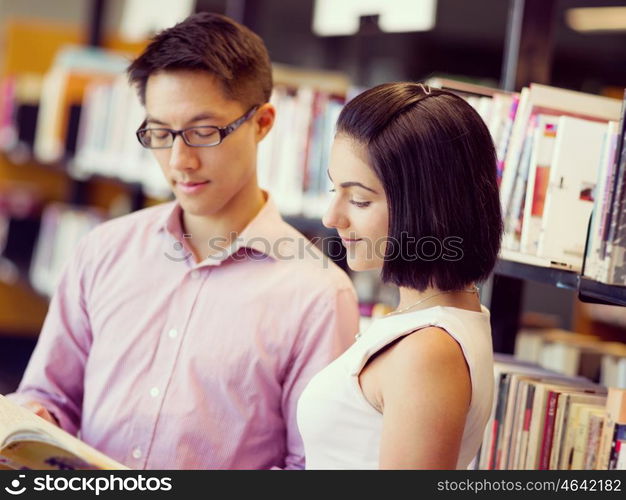 Group of young students at the library. Group of young students working together at the library