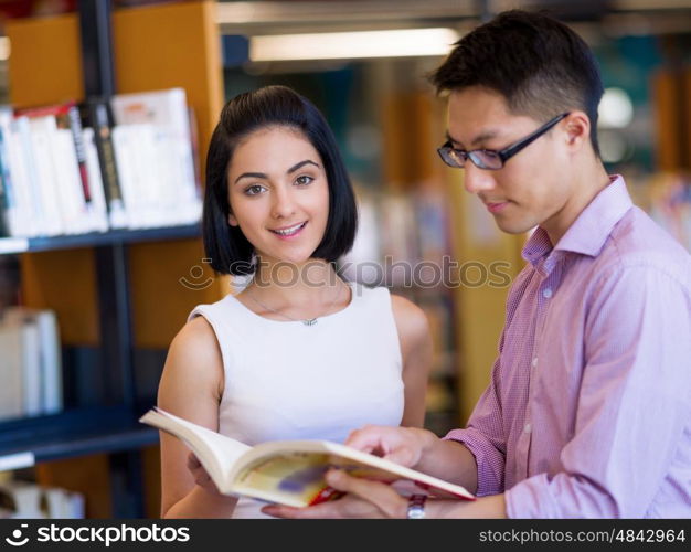 Group of young students at the library. Group of young students working together at the library