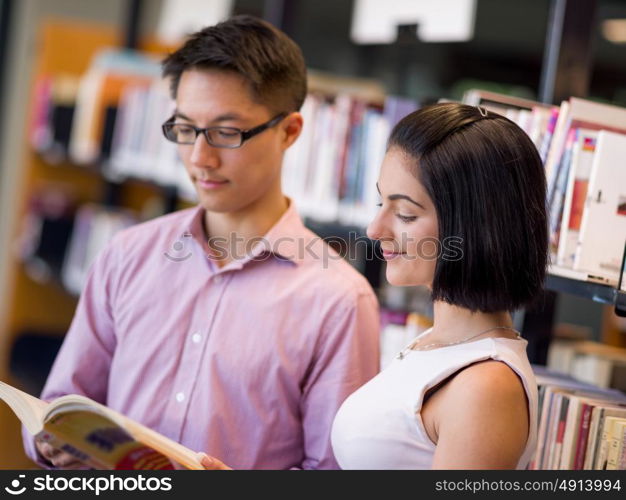 Group of young students at the library. Group of young students working together at the library