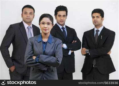 Group portrait of confident business people standing against gray background