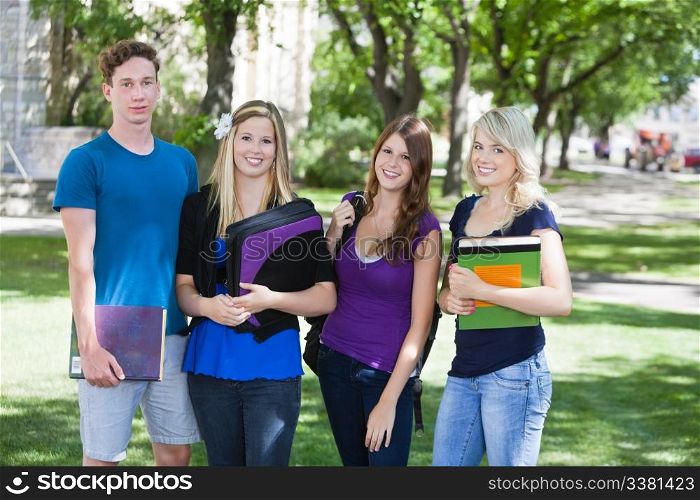 Group portrait of four college students on campus