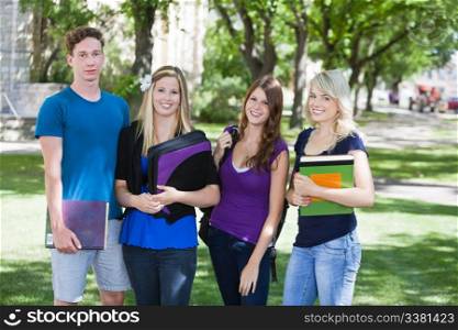 Group portrait of four college students on campus
